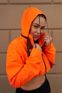 Sesión editorial streetwear para moda urbana, marca personal y contenido visual. Fotografía editorial streetwear con chaqueta naranja en exterior urbano