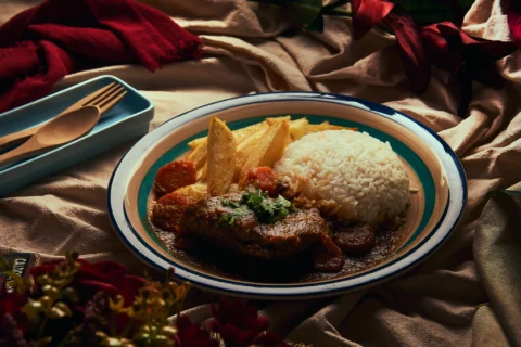 Fotografía gastronómica cálida para restaurantes, menús y contenido comercial. Fotografía gastronómica de plato casero con arroz, carne, papas y salsa en composición cálida