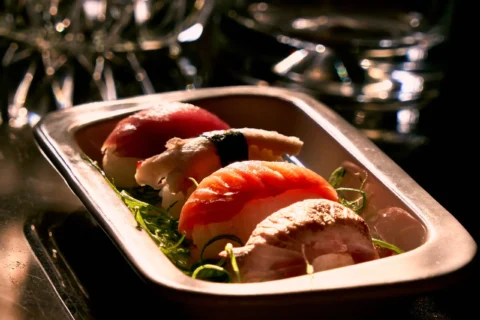 Fotografía gastronómica de sushi para restaurantes, cartas digitales y contenido comercial. Fotografía gastronómica de nigiri sushi servido en bandeja con iluminación cálida de restaurante